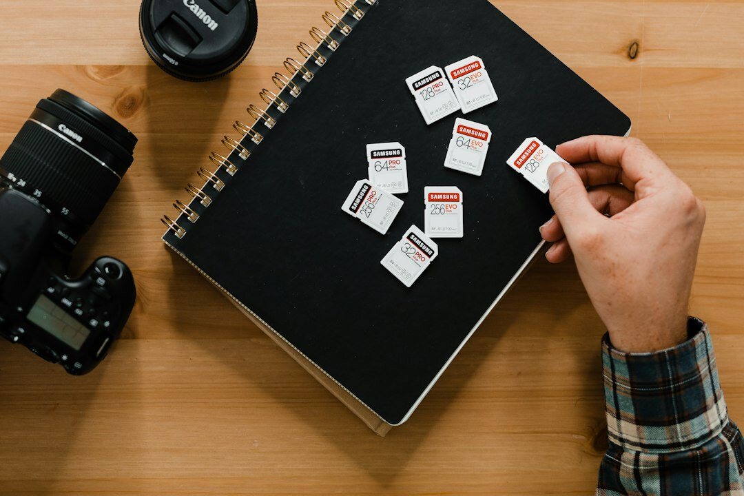 Photographer reviewing photo prints on a table with a notebook