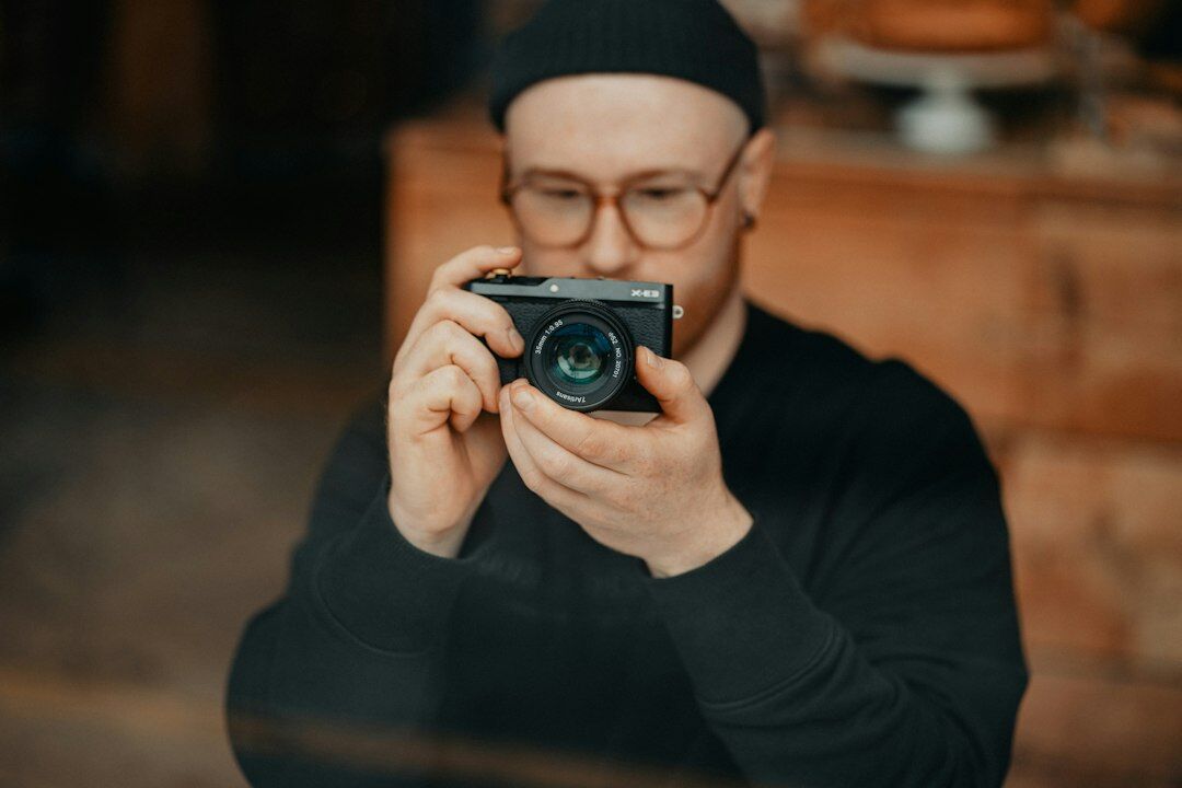 Portrait of a Danish documentary photographer holding a camera