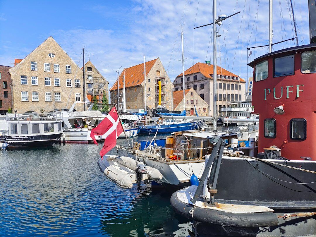 Elderly Danish fisherman mending nets by the harbour